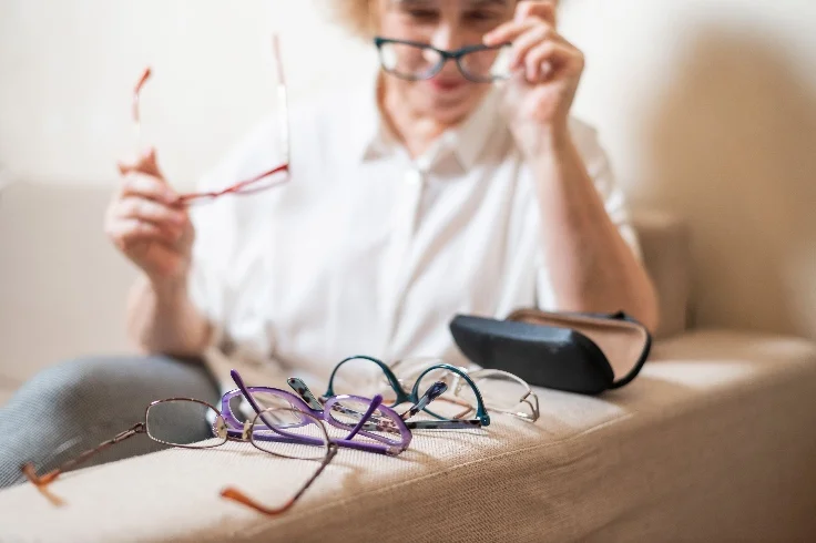 Femme qui essaye différentes montures de lunettes depuis son domicile
