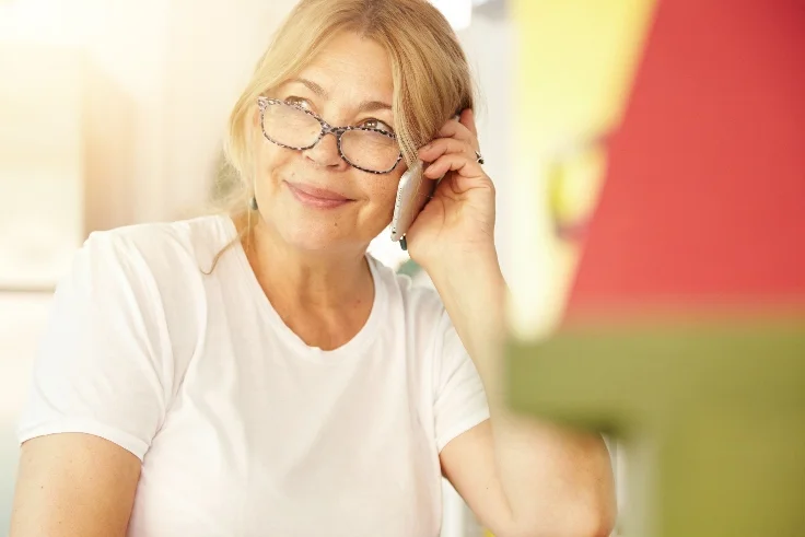 Personne âgée appelant son opticien à domicile pour refaire ses lunettes
